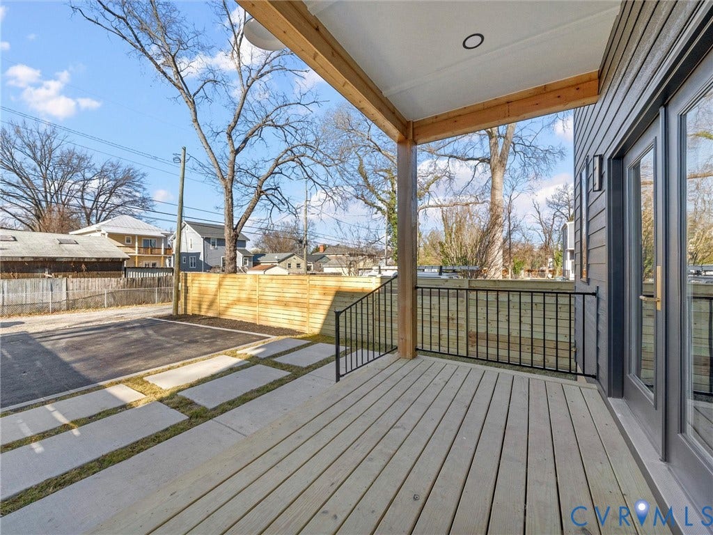2202 3rd Avenue, Northside, Richmond, VA 23222 Expansive wood deck with black metal railings, leading to a concrete patio with integrated grass strips