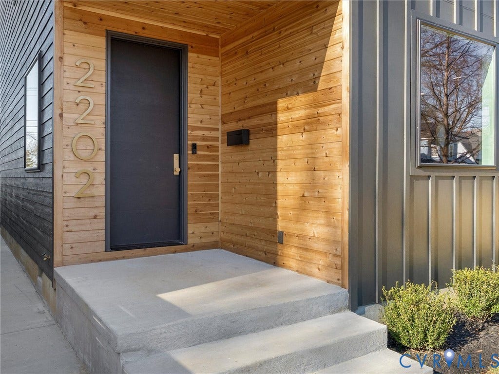 2202 3rd Avenue, Northside, Richmond, VA 23222 Concrete entry steps and landing with natural wood-tone siding and a dark flat-panel entry door