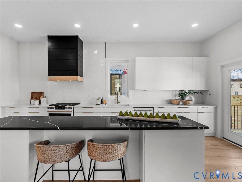 2202 3rd Avenue, Northside, Richmond, VA 23222 White kitchen featuring black countertops, wood-finish flooring, a black and wood-finish range hood, recessed lighting, and white cabinetry