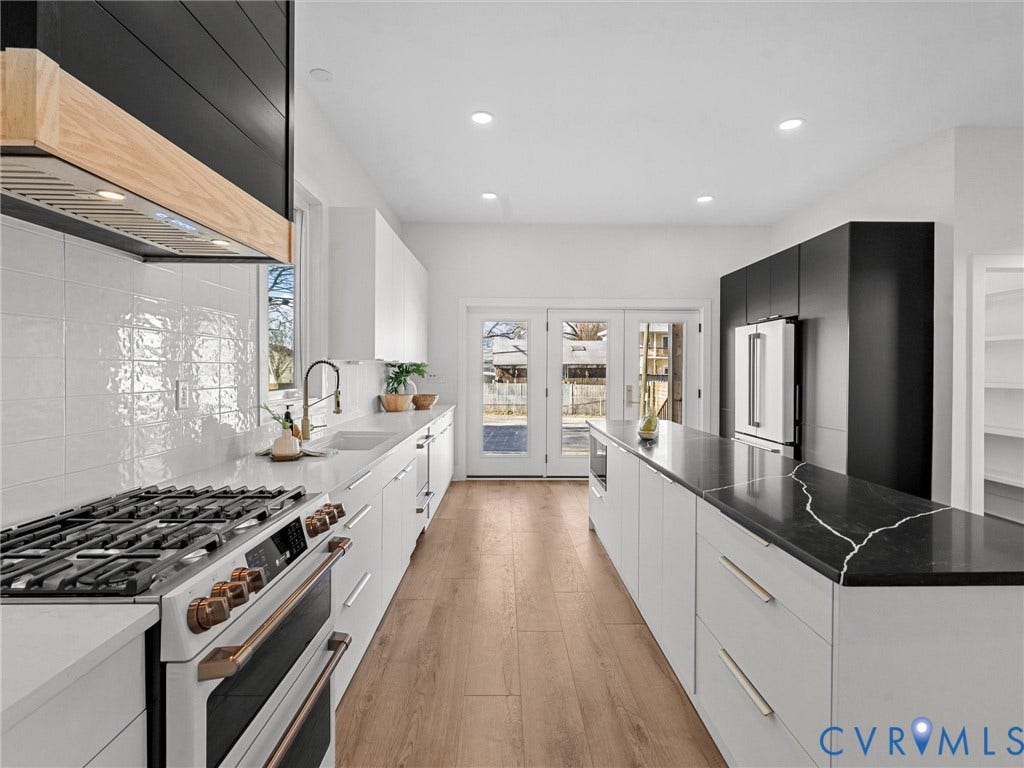 2202 3rd Avenue, Northside, Richmond, VA 23222 Modern kitchen featuring wood-finish flooring, white cabinetry, a black and wood range hood, a gas range, and a kitchen island with a dark countertop