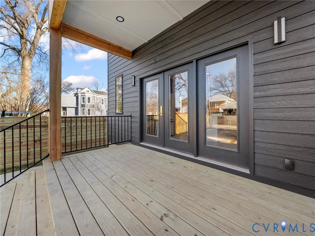 2202 3rd Avenue, Northside, Richmond, VA 23222 Expansive outdoor deck with wood-finish flooring, black iron railings, dark paneled siding, and double glass-paneled doors