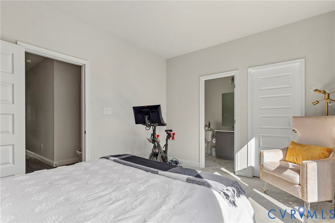 Spacious room with light-toned walls, white trim, and panel doors