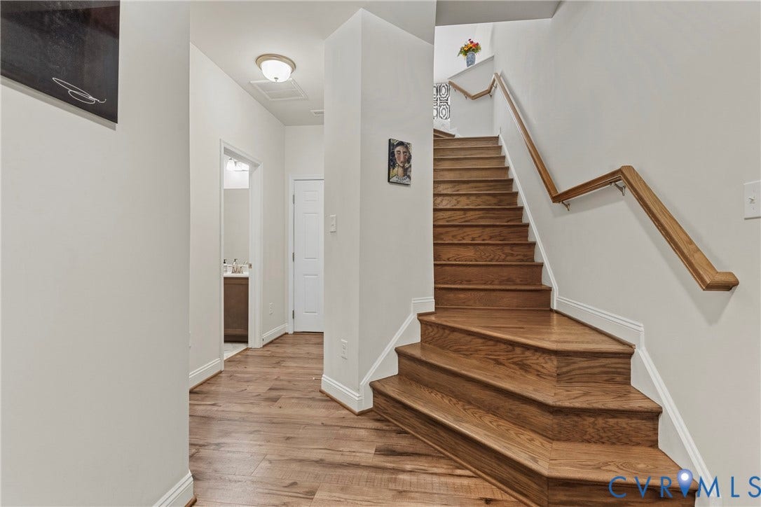 Hardwood flooring and staircase with wood railing