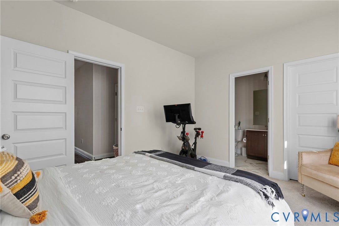 Light-colored walls with trim, white five-panel doors, and carpeted flooring
