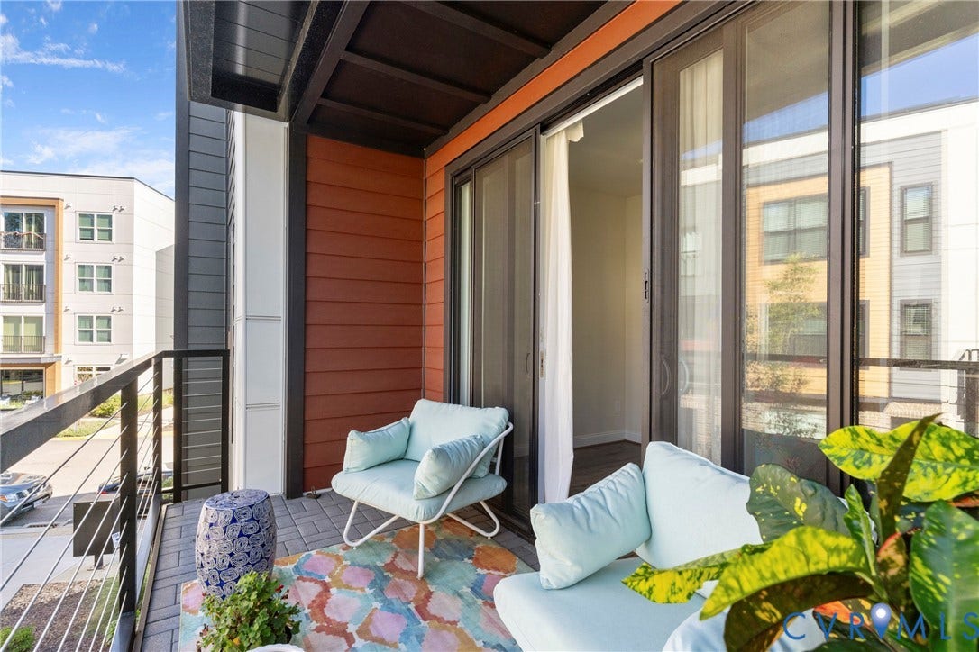 Balcony with dark-stained wood ceiling, cable railing, and a sliding glass door