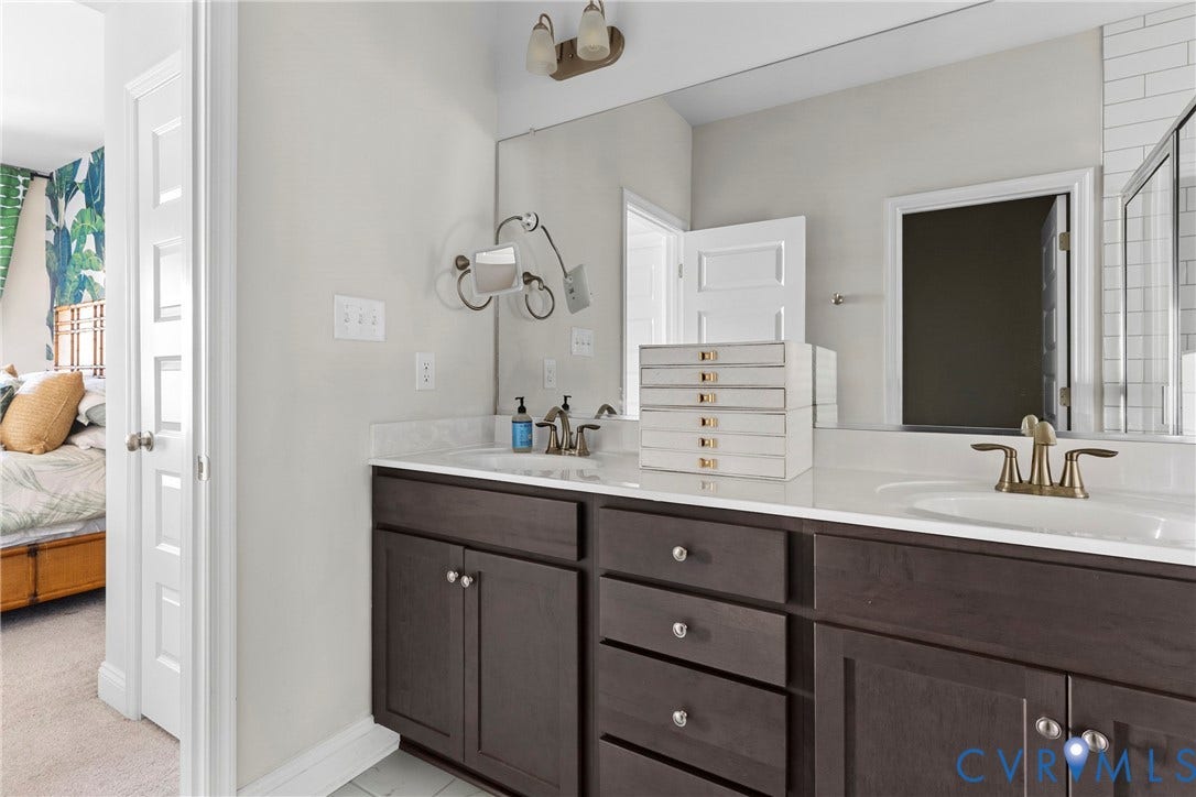 Dual vanity with dark wood-finish cabinetry, white countertop, and integrated sinks