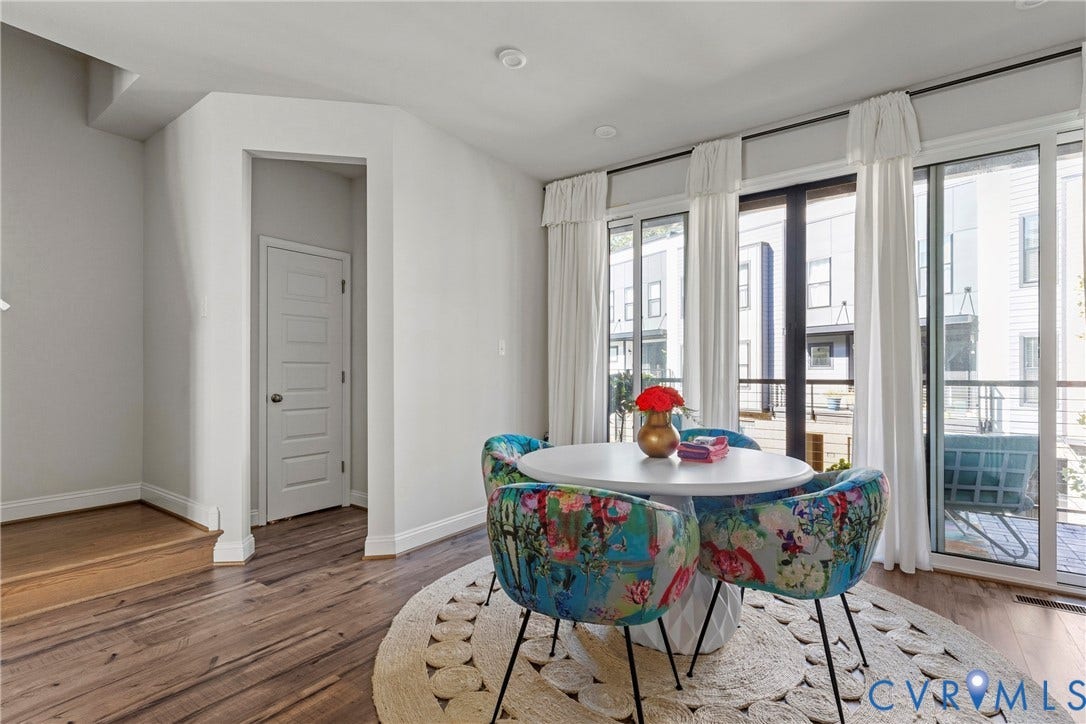 Bright corner residence featuring floor-to-ceiling glass doors and windows with sheer drapery, abundant natural light, and hardwood flooring throughout