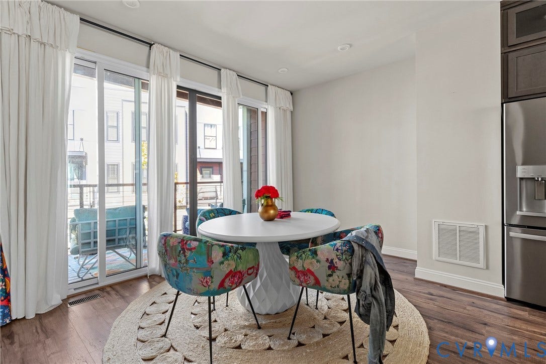 Spacious room with wood-finish flooring, recessed lighting, and multiple sliding glass doors to outdoor balcony