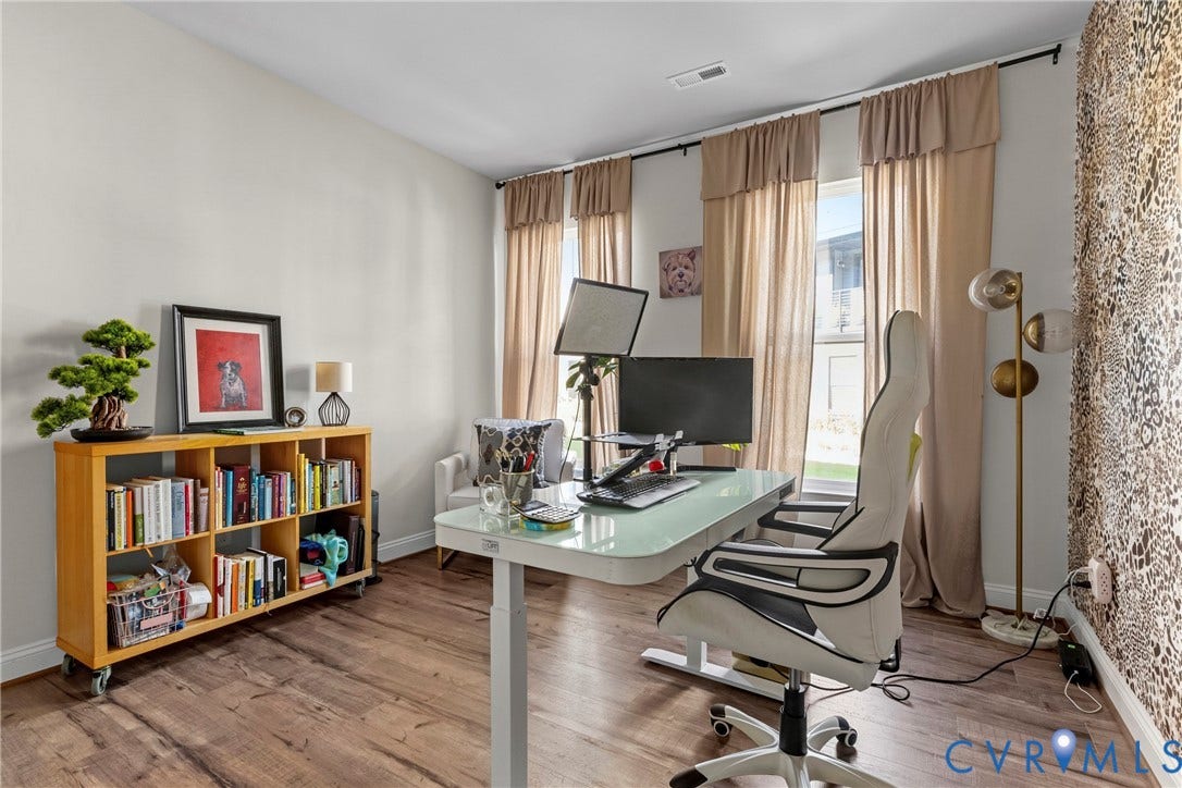 Wood-finish flooring, multiple windows providing natural light, recessed lighting, and a built-in bookshelf
