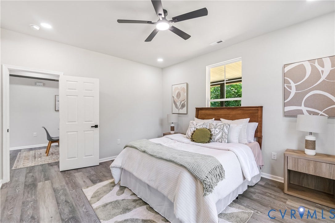 Recessed lighting, wood-finish flooring, a ceiling fan, a paneled door, and a transom window