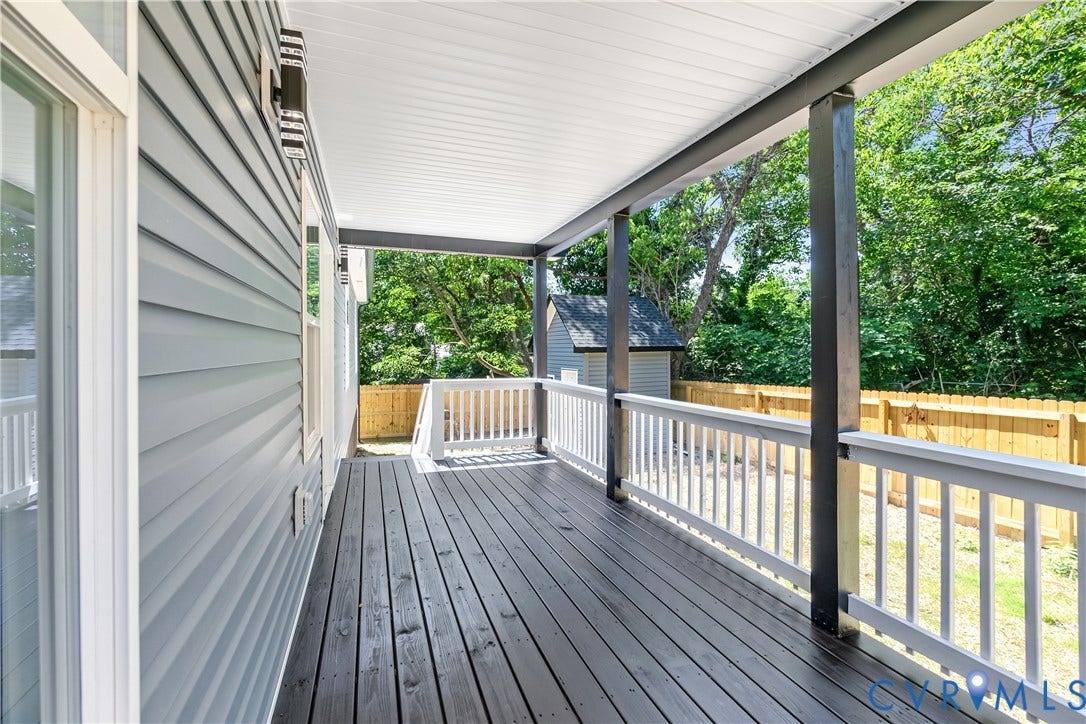 Covered patio featuring a wood-finish floor and white railings