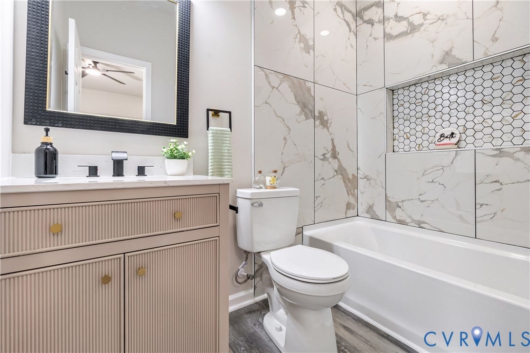 Vanity with fluted cabinet doors, white countertop, and matte black faucet
