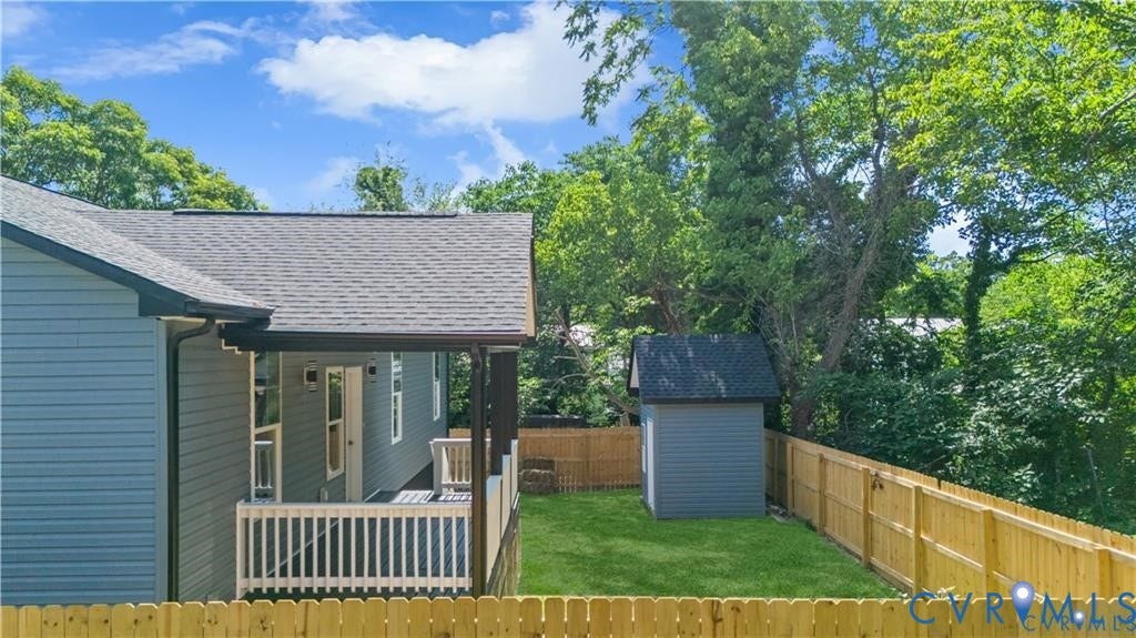 Covered porch with white railings, grey siding, and a gabled roof