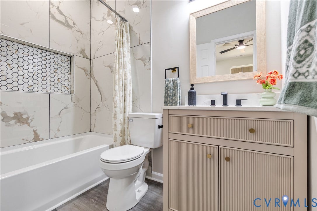 Bathroom featuring a modern vanity with textured drawer and cabinet fronts, a white countertop, and matte black fixtures