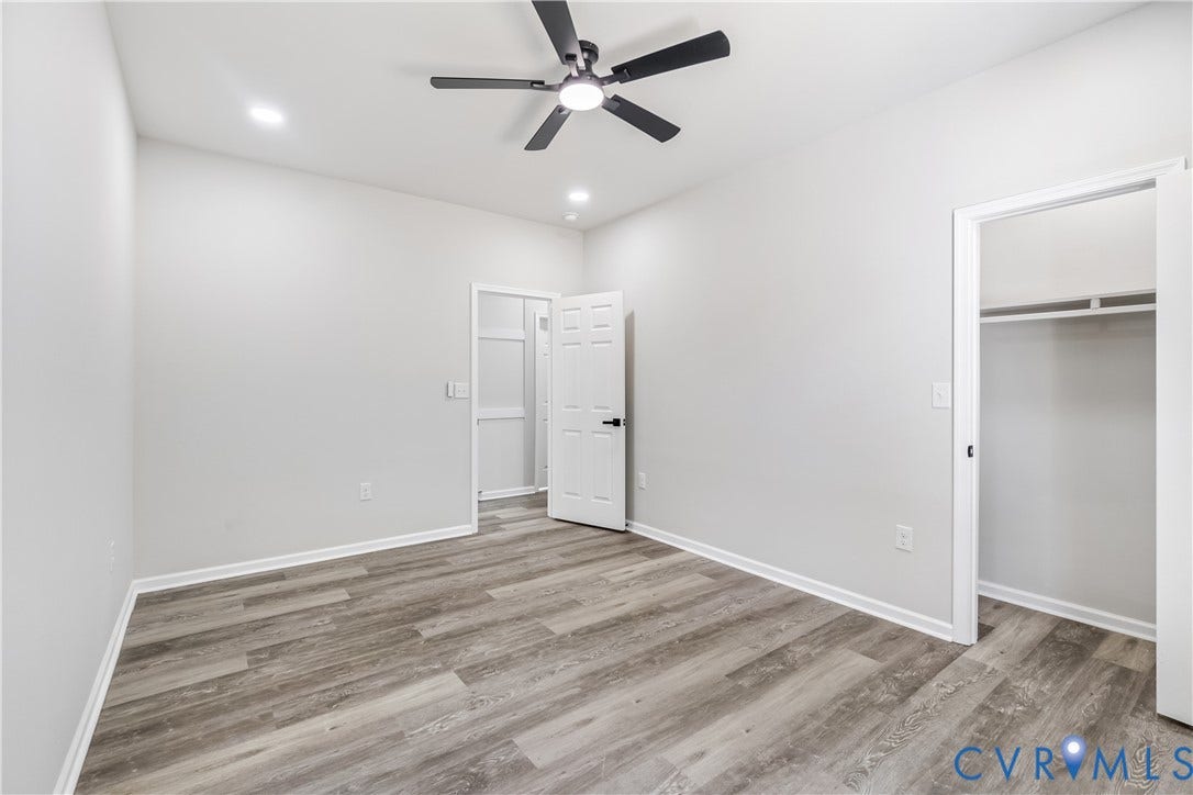 Spacious room featuring wood-finish flooring, recessed lighting, and a ceiling fan