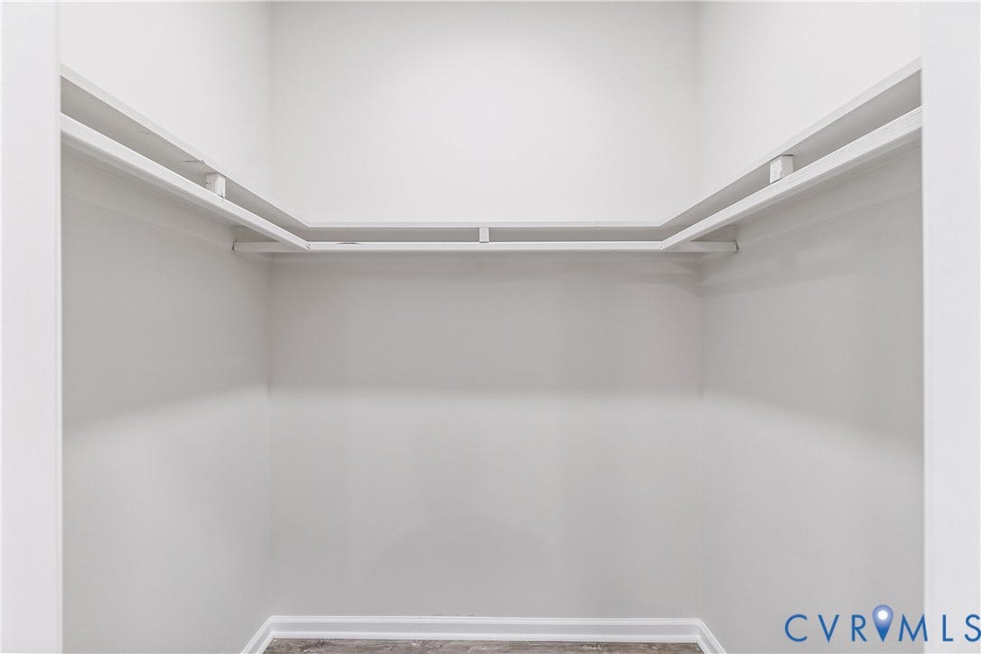Walk-in closet with built-in shelving and hanging rods