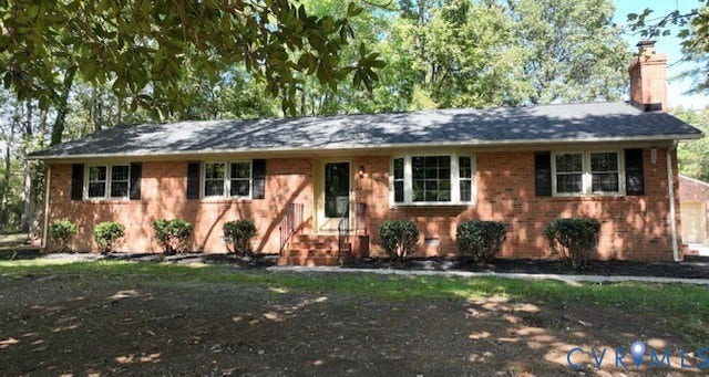Brick exterior with a prominent bay window, dark shutters, and a shingle roof