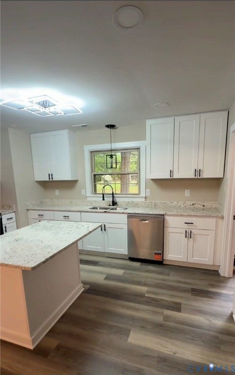 Kitchen featuring white shaker cabinetry, speckled countertops, wood-finish flooring, a stainless steel dishwasher, and a centered window with a pendant light fixture