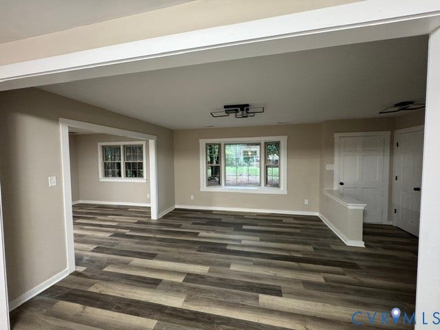 Wood-finish flooring, neutral wall tones, multiple windows, and modern ceiling light fixtures