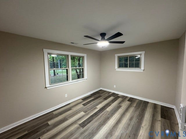Wood-finish flooring, neutral wall tones, and white trim throughout