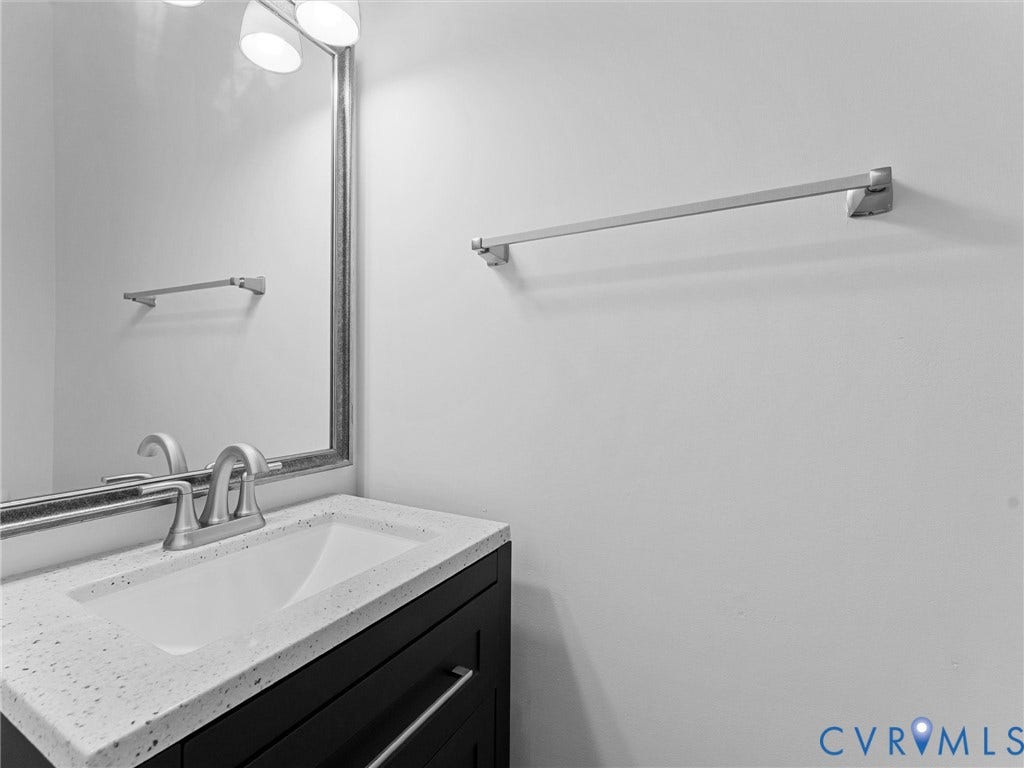 Vanity with an integrated sink, speckled countertop, and brushed nickel faucet