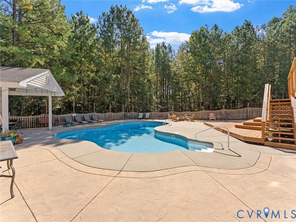 Freeform swimming pool with integrated spa and concrete surround