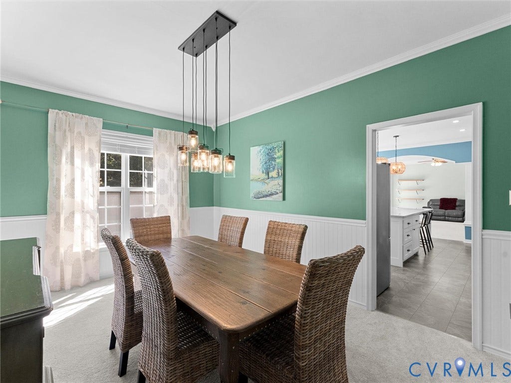 Recessed panel wainscoting, decorative crown molding, and a multi-light pendant fixture