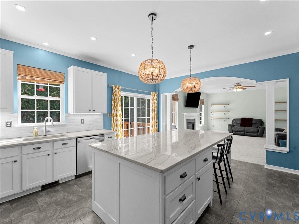 Kitchen featuring a center island, white cabinetry, a tiled backsplash, and recessed lighting