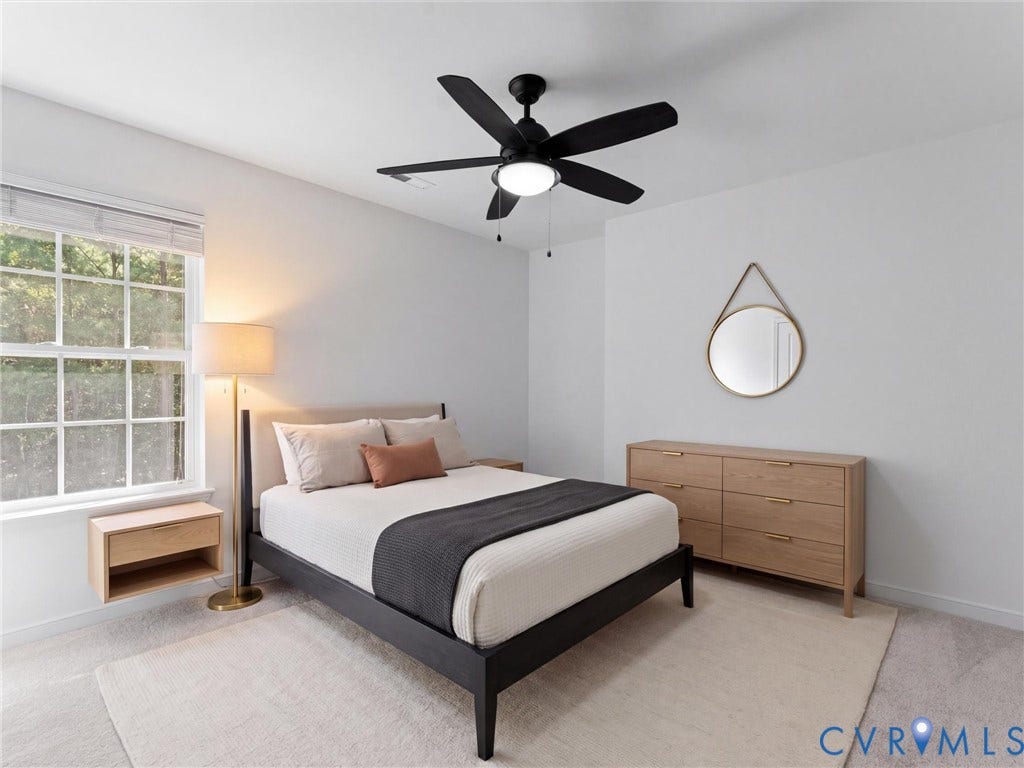 Carpeted room featuring a ceiling fan with integrated lighting, a window, and a built-in floating nightstand
