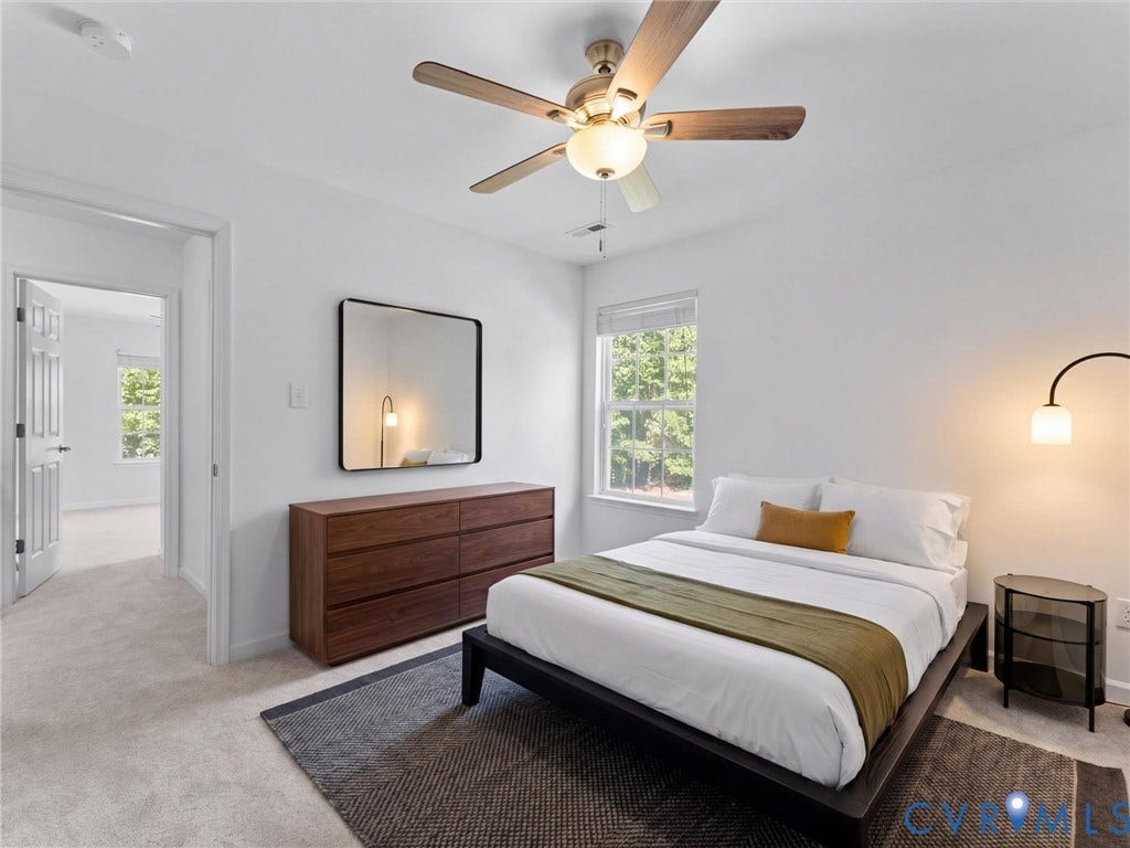 White walls with carpet flooring, a ceiling fan with integrated lighting, and a window with blinds