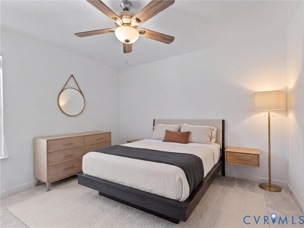 Carpeted flooring, white walls, and a ceiling fan with light fixture