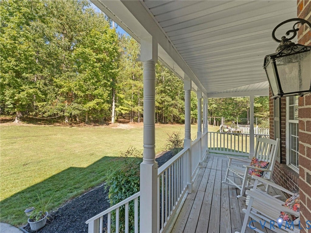 Expansive covered porch with a wood-finish floor and white railings