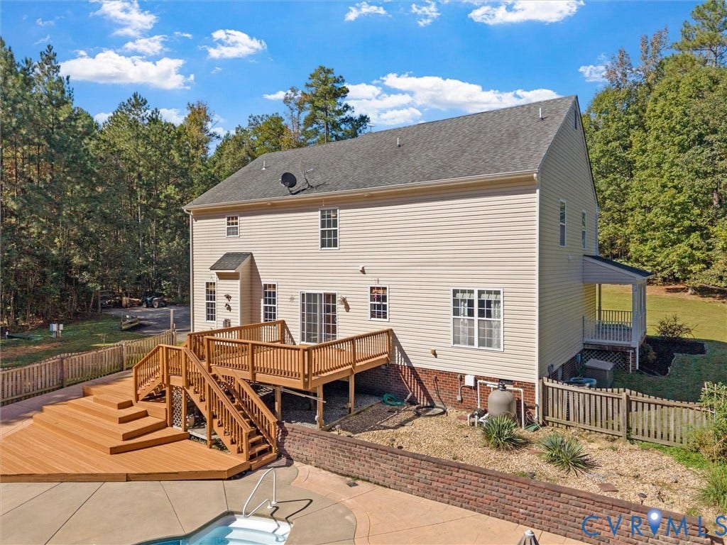 Exterior with light-toned siding, multi-level wood deck, concrete patio surrounding an in-ground pool, and a covered porch