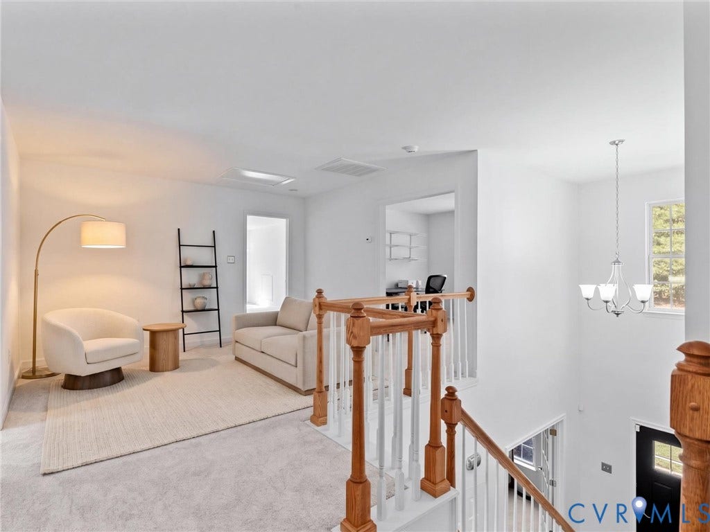 Carpeted loft area featuring a skylight, white walls, and a recessed ceiling