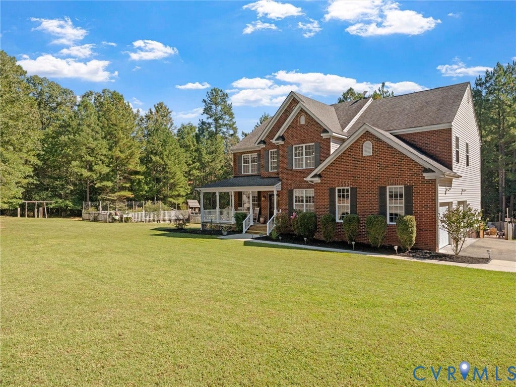 Brick exterior with white siding accents and a covered porch