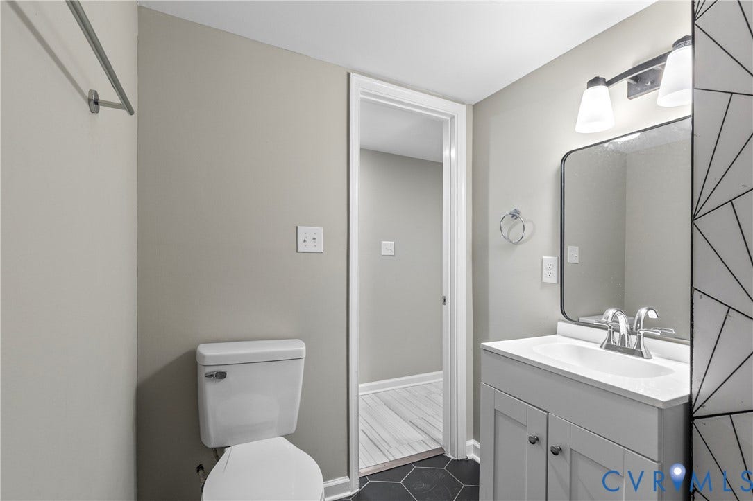 2606 Hawthorne Avenue, Richmond, VA 23222 White vanity with integrated sink, contemporary mirror, and two-light fixture