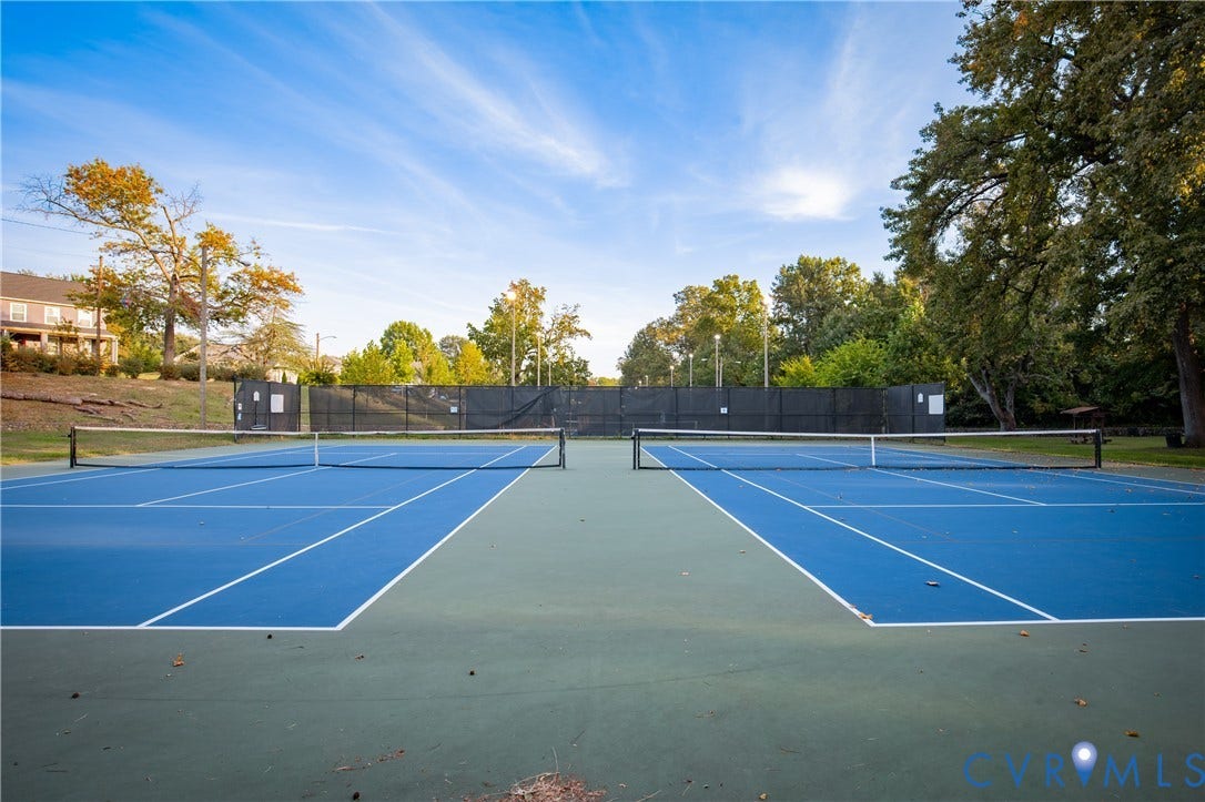 2606 Hawthorne Avenue, Richmond, VA 23222 Two blue tennis courts with white line markings, surrounded by perimeter fencing and mature trees