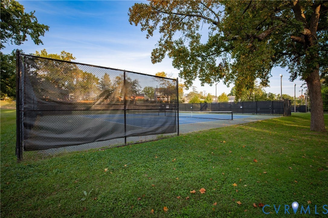 2606 Hawthorne Avenue, Richmond, VA 23222 Outdoor tennis courts featuring a blue playing surface, black perimeter fencing, and mature trees