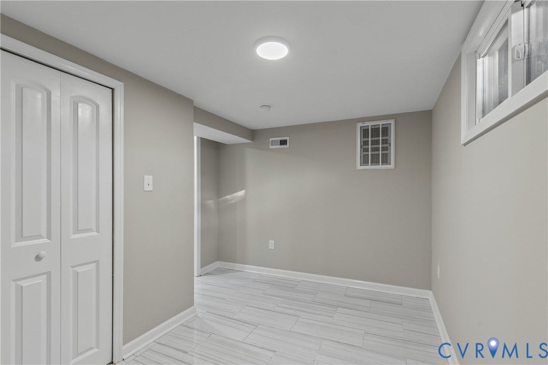 2606 Hawthorne Avenue, Richmond, VA 23222 Recessed lighting, wood-finish flooring, light gray walls, white bi-fold doors, and a window with white trim