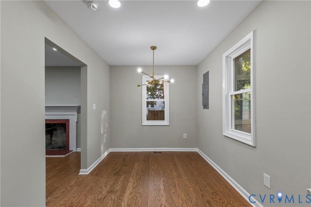 2606 Hawthorne Avenue, Richmond, VA 23222 Hardwood flooring, two windows, recessed lighting, brass-finish chandelier, and a fireplace with a white mantel
