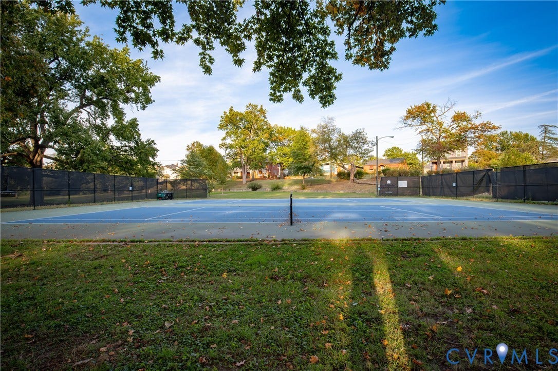 2606 Hawthorne Avenue, Richmond, VA 23222 Tennis court with blue surfacing, surrounded by black chain-link fencing, and mature trees