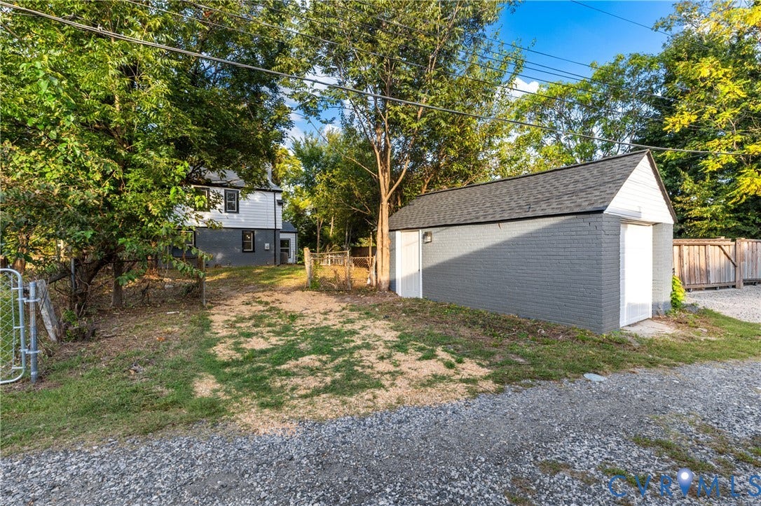 2606 Hawthorne Avenue, Richmond, VA 23222 Detached garage with gray painted brick exterior and white trim, featuring a dark shingle roof and a separate side entry