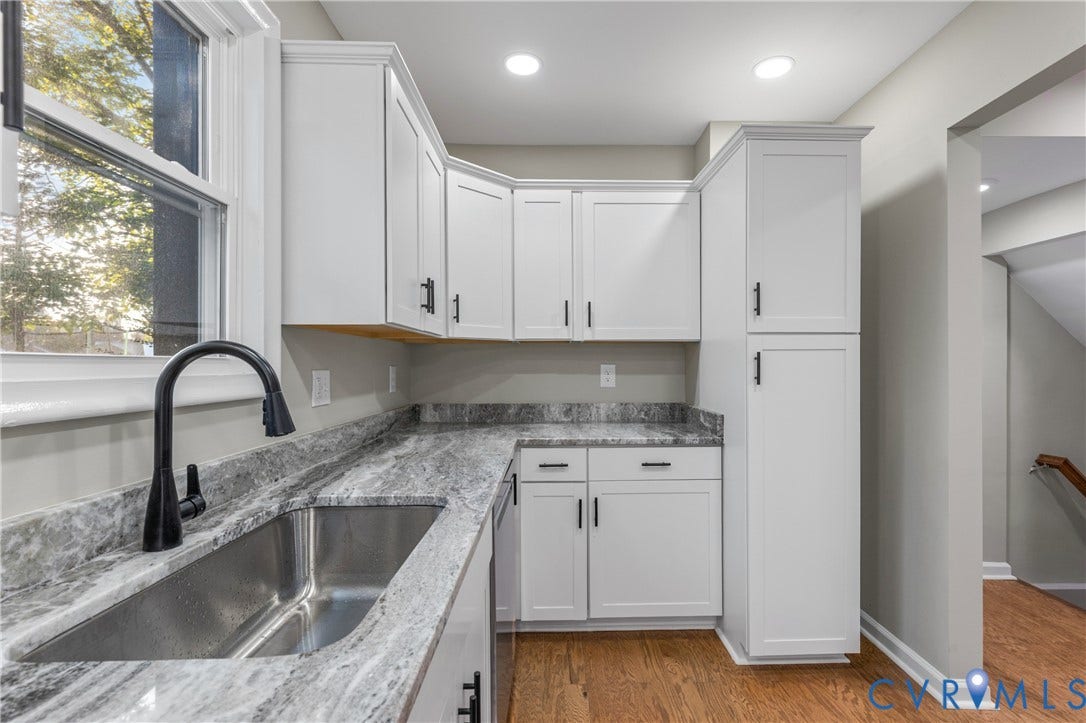 2606 Hawthorne Avenue, Richmond, VA 23222 White cabinetry with crown molding, stainless steel sink with matte black faucet, and stone-finish countertops