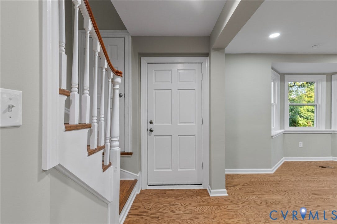 2606 Hawthorne Avenue, Richmond, VA 23222 Hardwood flooring, painted paneled door, staircase with wood banister, recessed lighting, and bay window