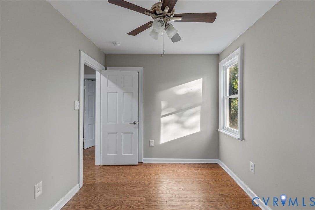 2606 Hawthorne Avenue, Richmond, VA 23222 Hardwood-finish flooring, light grey painted walls, ceiling fan with integrated lighting, and a white-framed window