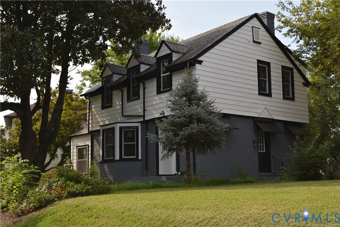 2606 Hawthorne Avenue, Richmond, VA 23222 White siding exterior with black trim, multiple dormer windows, a bay window, and a prominent chimney