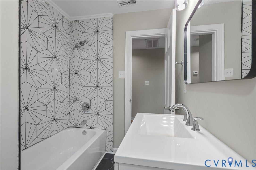 2606 Hawthorne Avenue, Richmond, VA 23222 Bathroom featuring a vanity with an integrated sink, polished chrome faucet, and a wall-mounted mirror