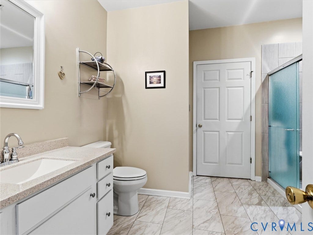 Bathroom featuring a single vanity with an integrated sink, polished chrome faucet, white cabinetry, and a textured countertop