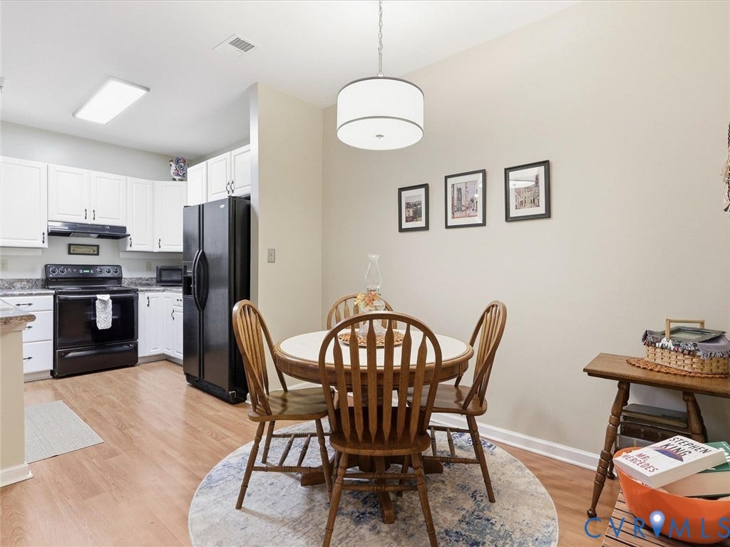 Laminate flooring, complemented by white cabinetry and dark countertops