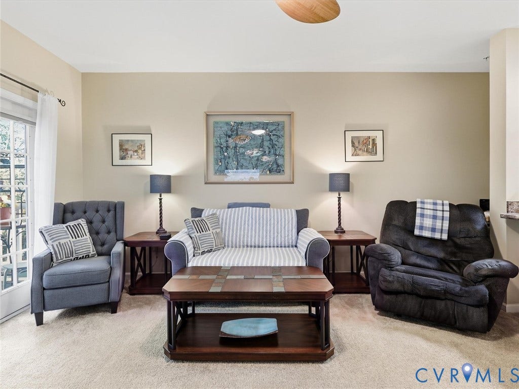 Plush carpet flooring, light neutral wall color, and a balcony with white French doors